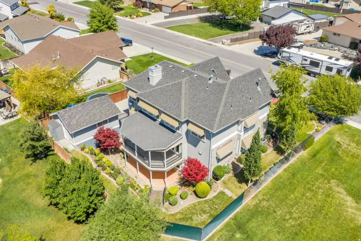 Two-story residence featuring a gray exterior, stone accents, and a multi-pitch roof