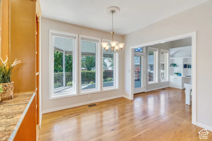 Open-concept living area featuring light wood-finish flooring and three large windows