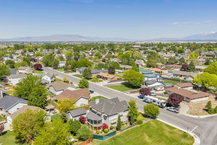 Aerial perspective showcasing a residential area with diverse home styles, mature trees, and paved streets