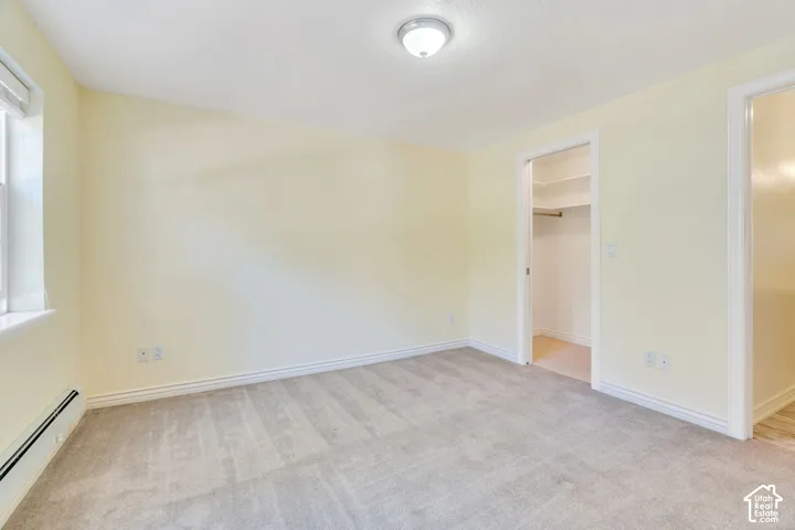 Neutral-toned room featuring light-colored walls, grey carpet flooring, and white trim