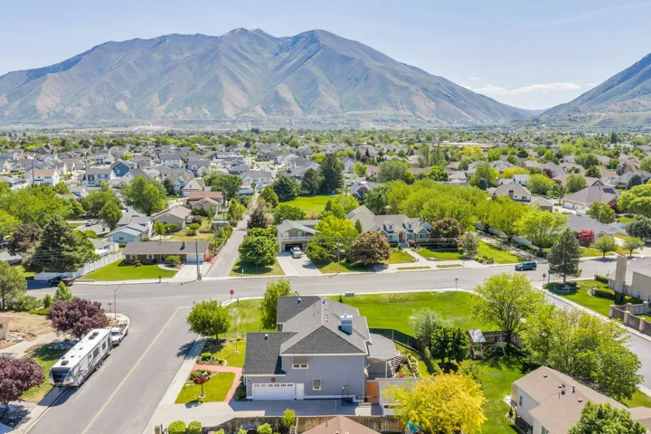 Residential area featuring paved streets, mature trees, and a mountain backdrop