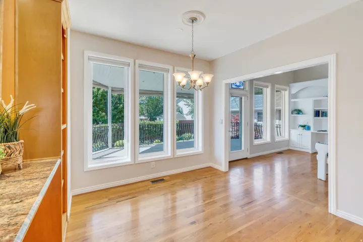Open-concept living area featuring light wood-finish flooring and three large windows