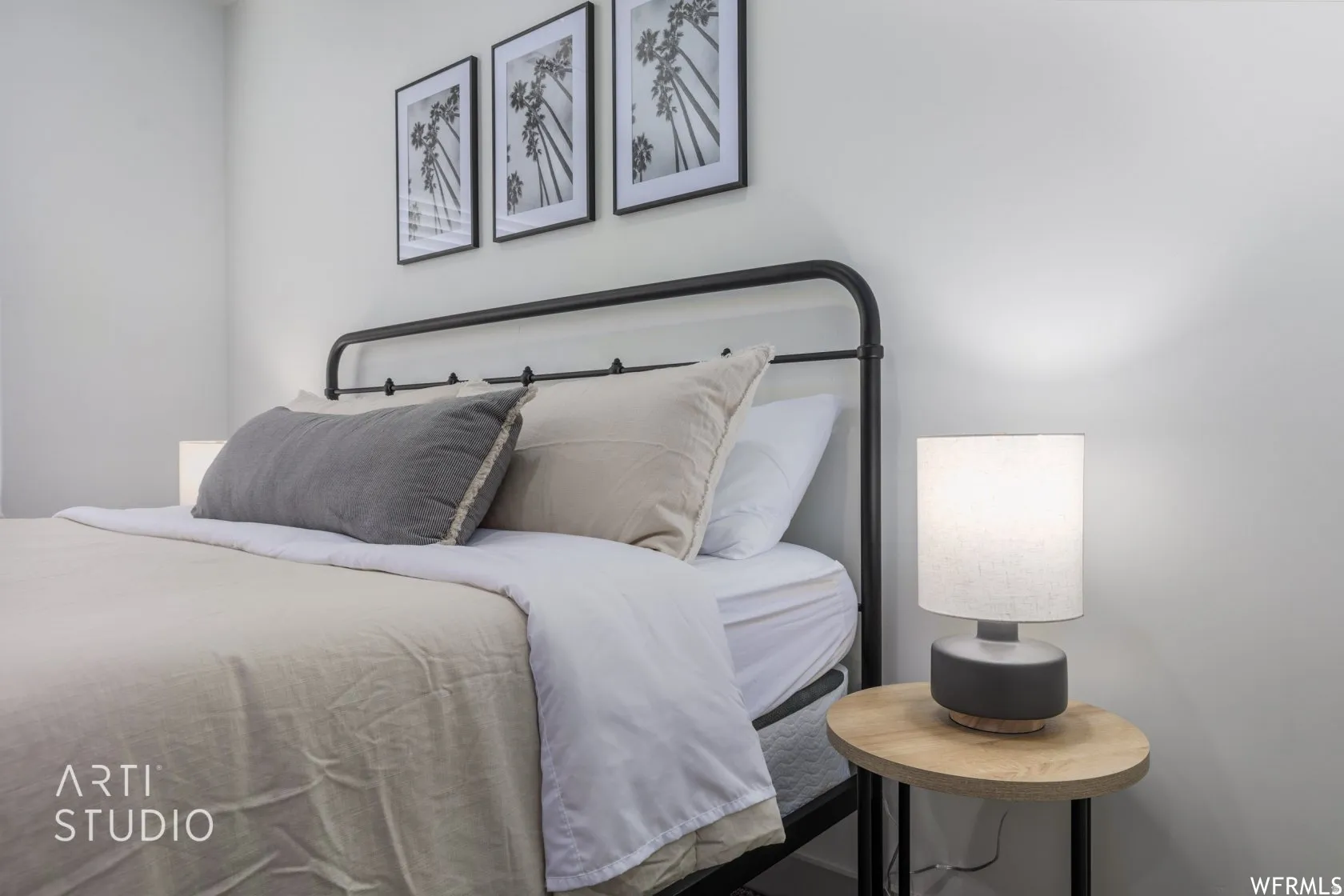 Light-filled bedroom featuring a black metal bed frame and white walls