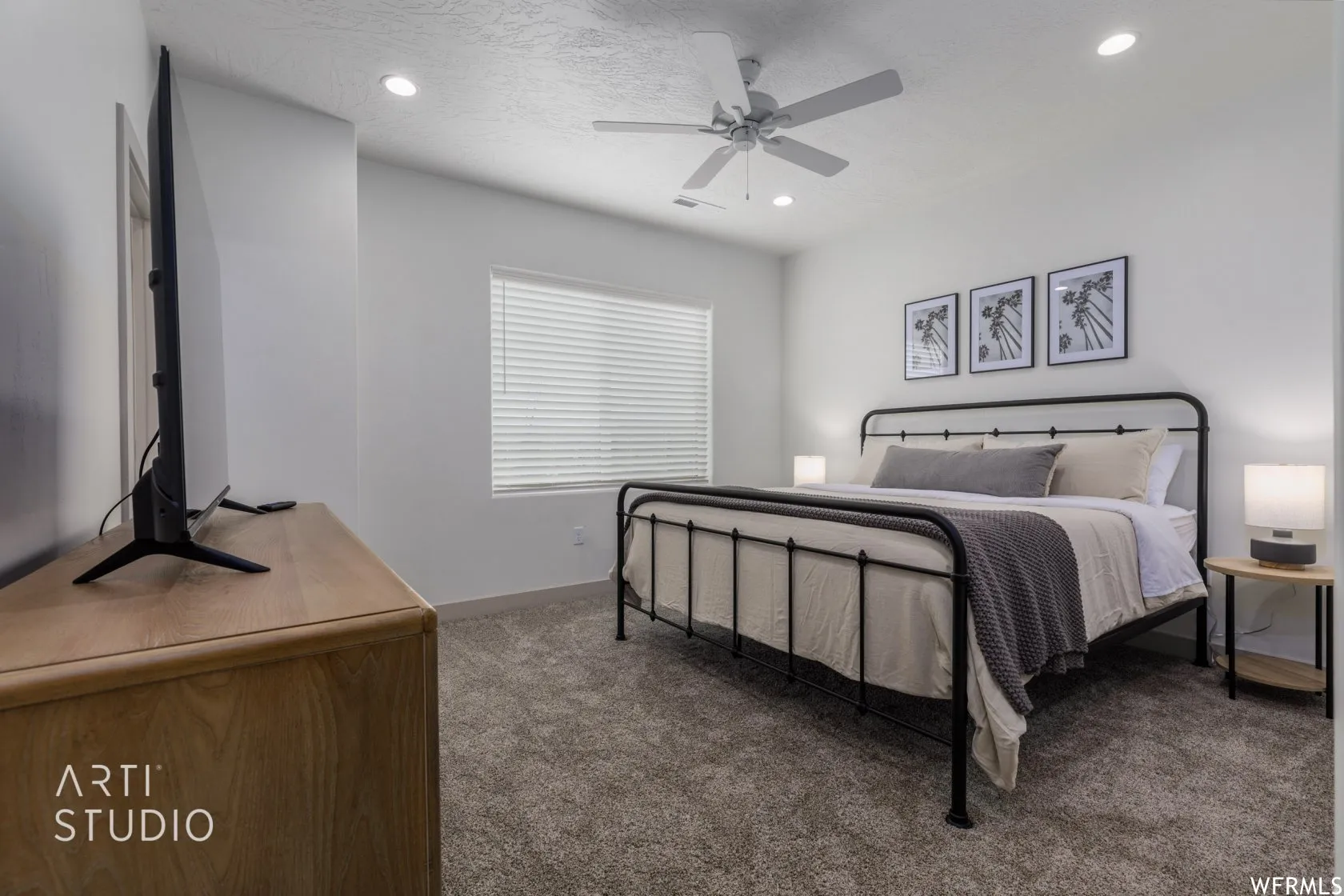 Carpeted room featuring a ceiling fan with integrated lighting, recessed lighting, and a window with blinds