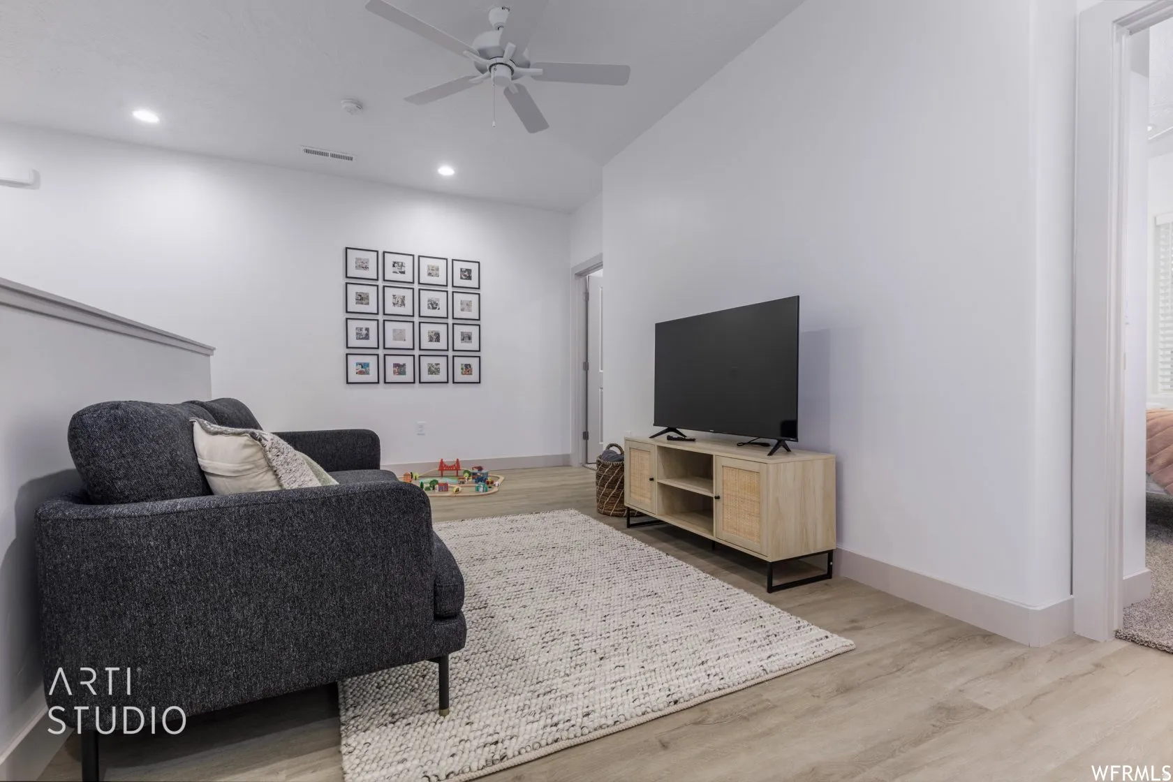Light wood-finish flooring complements the bright white walls and recessed lighting