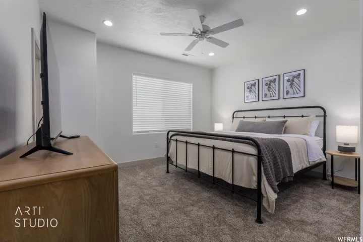 Carpeted room featuring a ceiling fan with integrated lighting, recessed lighting, and a window with blinds