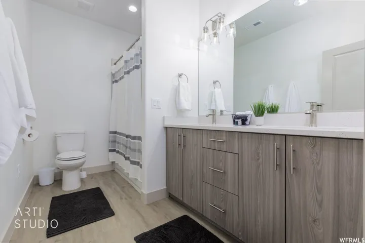 Double vanity with white countertop, chrome fixtures, and wood-finish cabinetry