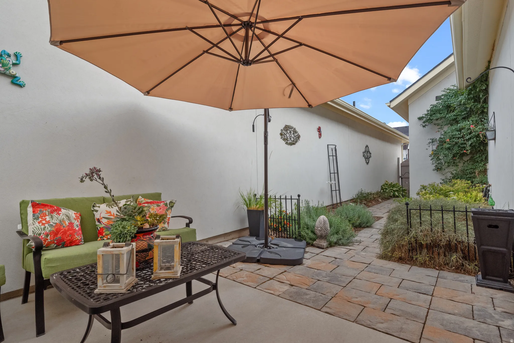 Outdoor paved patio area featuring a large, neutral-toned umbrella