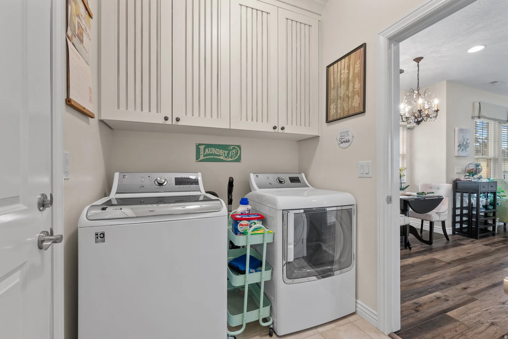 Dedicated laundry area featuring upper cabinetry with beadboard paneling and under-cabinet lighting