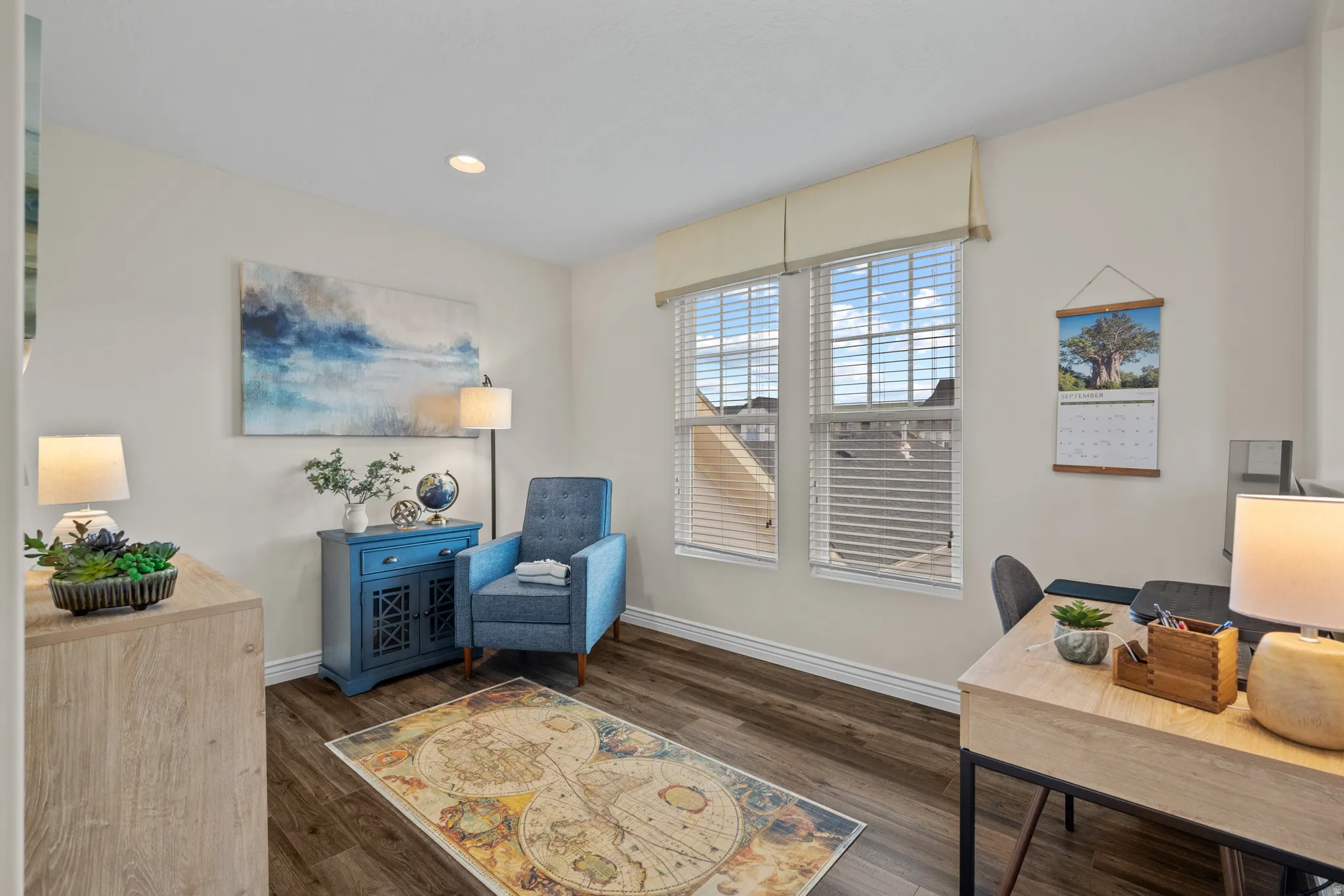 Bright room with two large windows featuring horizontal blinds and a neutral valance