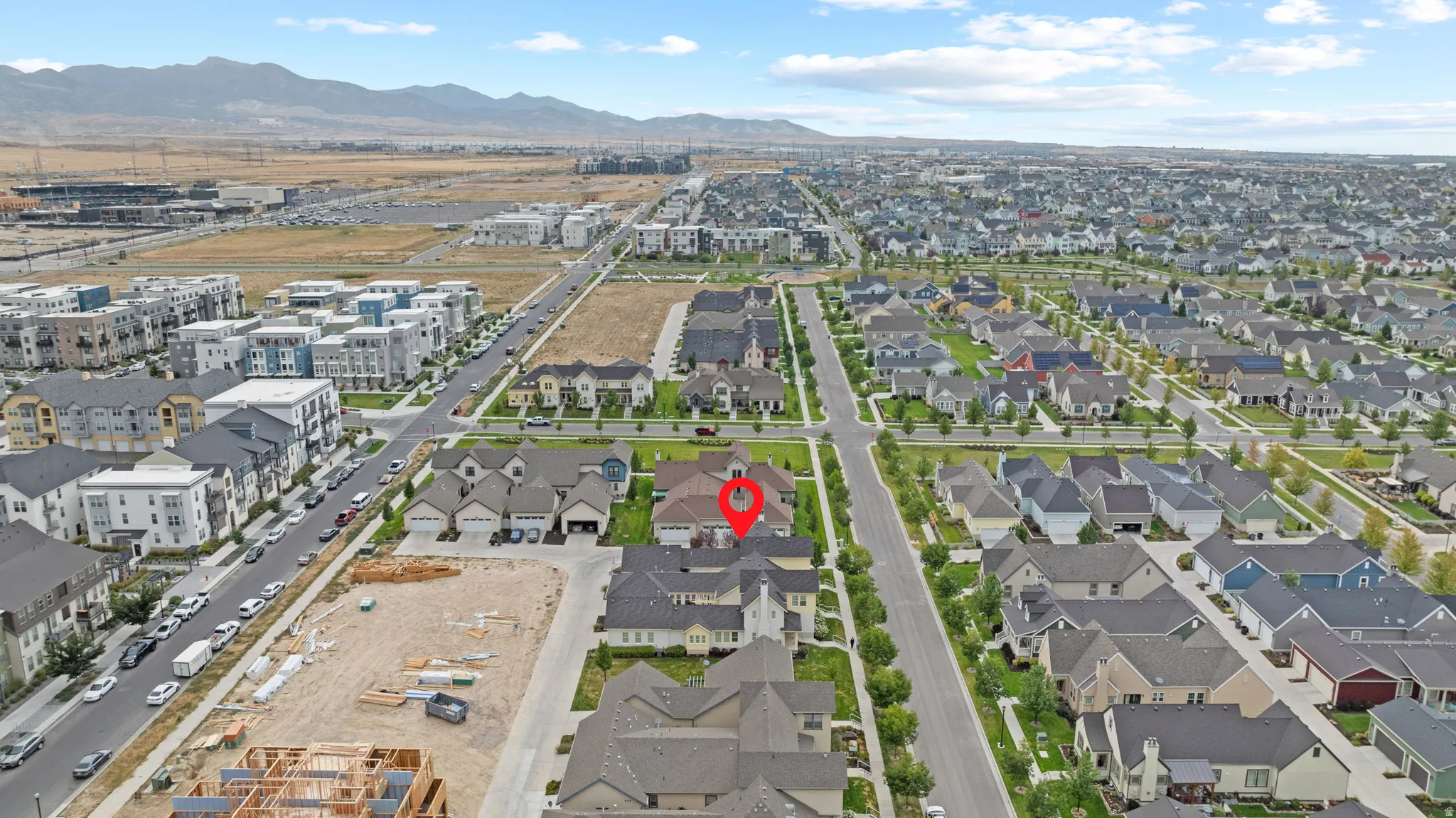 Sprawling residential development featuring diverse architectural styles, extensive paved roads, and distant mountain backdrops
