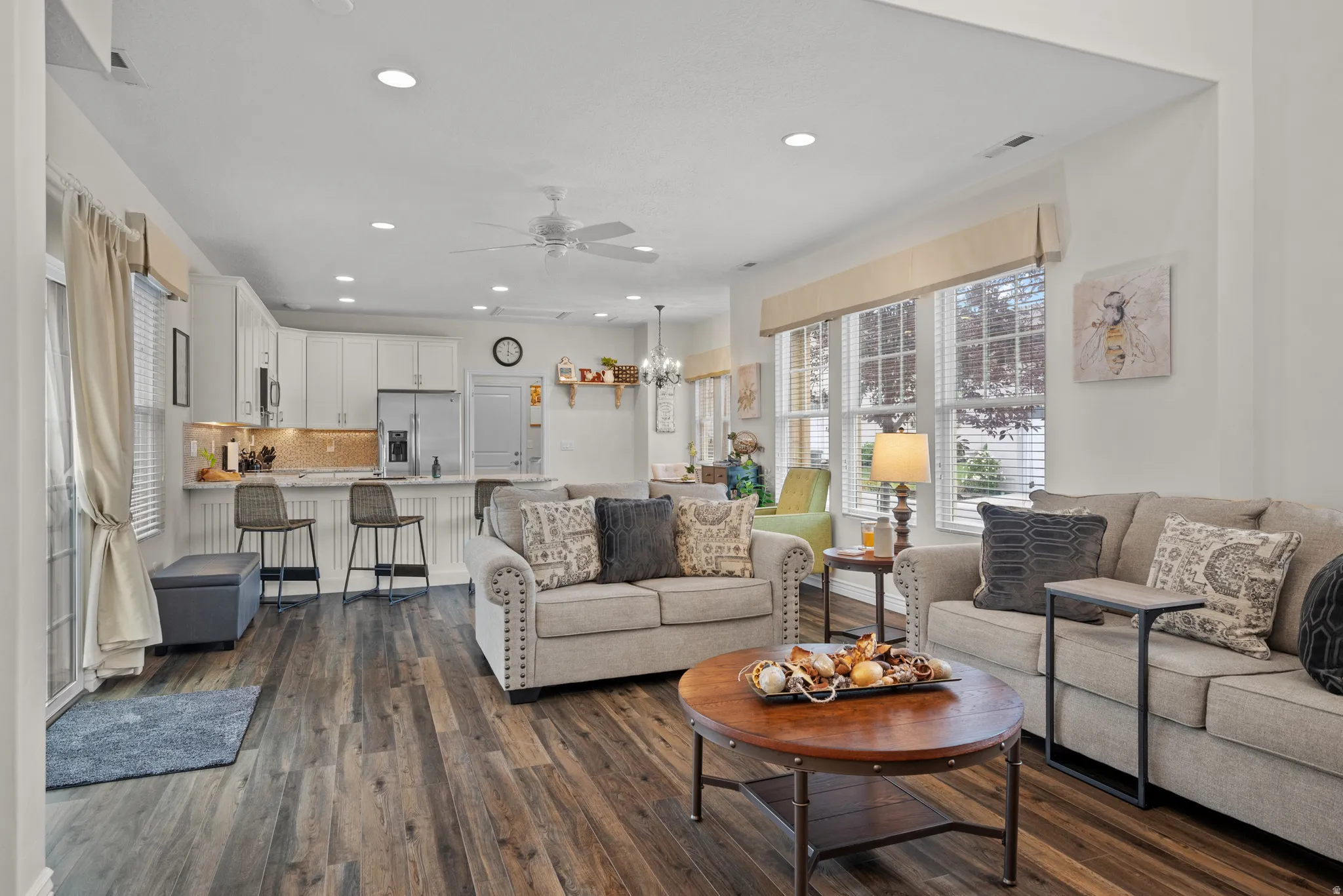 Open-concept living area featuring wood-finish flooring, recessed lighting, and a ceiling fan
