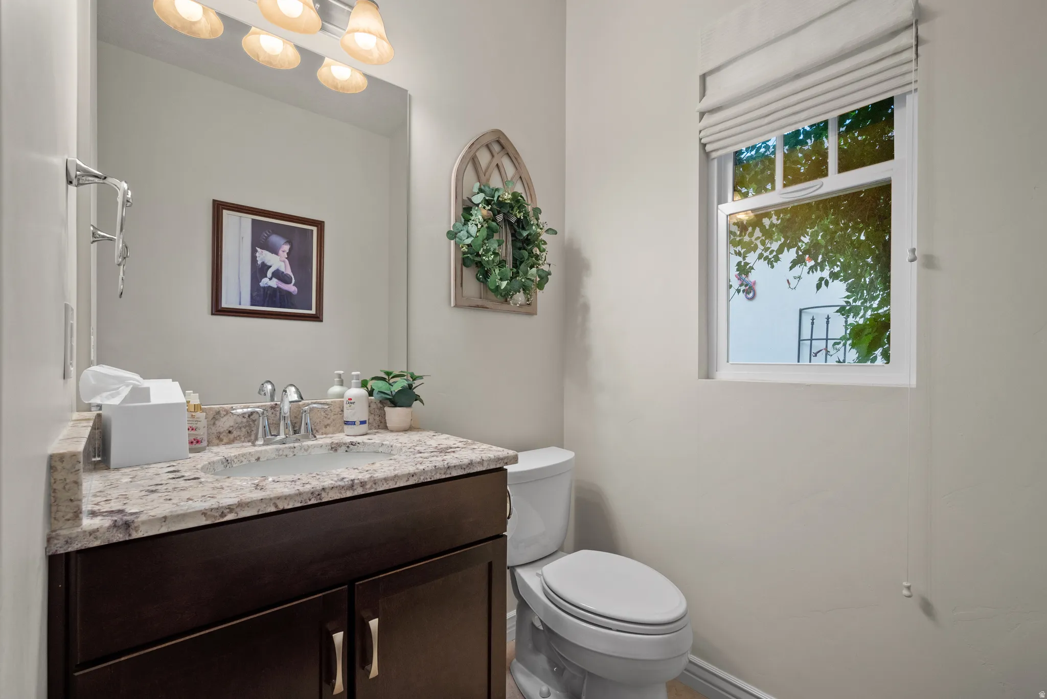Powder room featuring a dark wood vanity with a granite countertop and an undermount sink