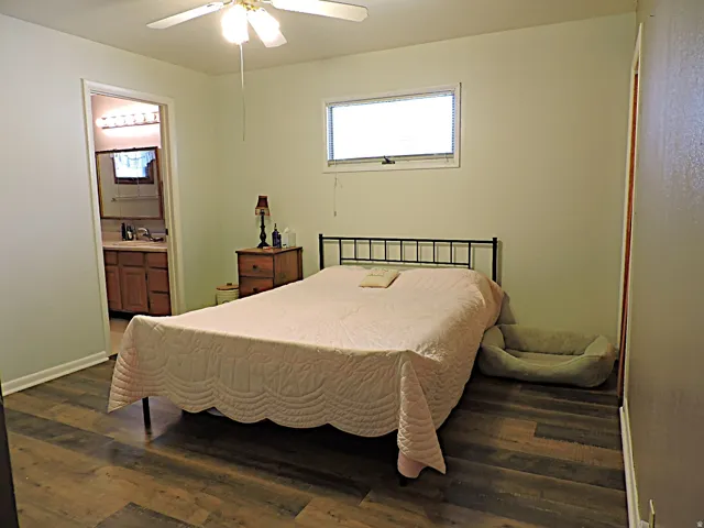 Bedroom featuring wood-finish flooring, a ceiling fan with integrated lighting, and a horizontal window with blinds
