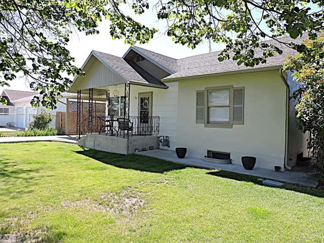 Front exterior featuring a covered porch, established lawn