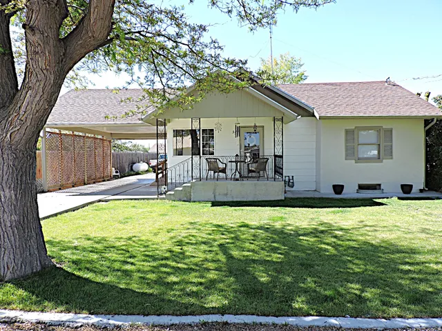 White exterior with a covered front porch featuring wrought iron railings