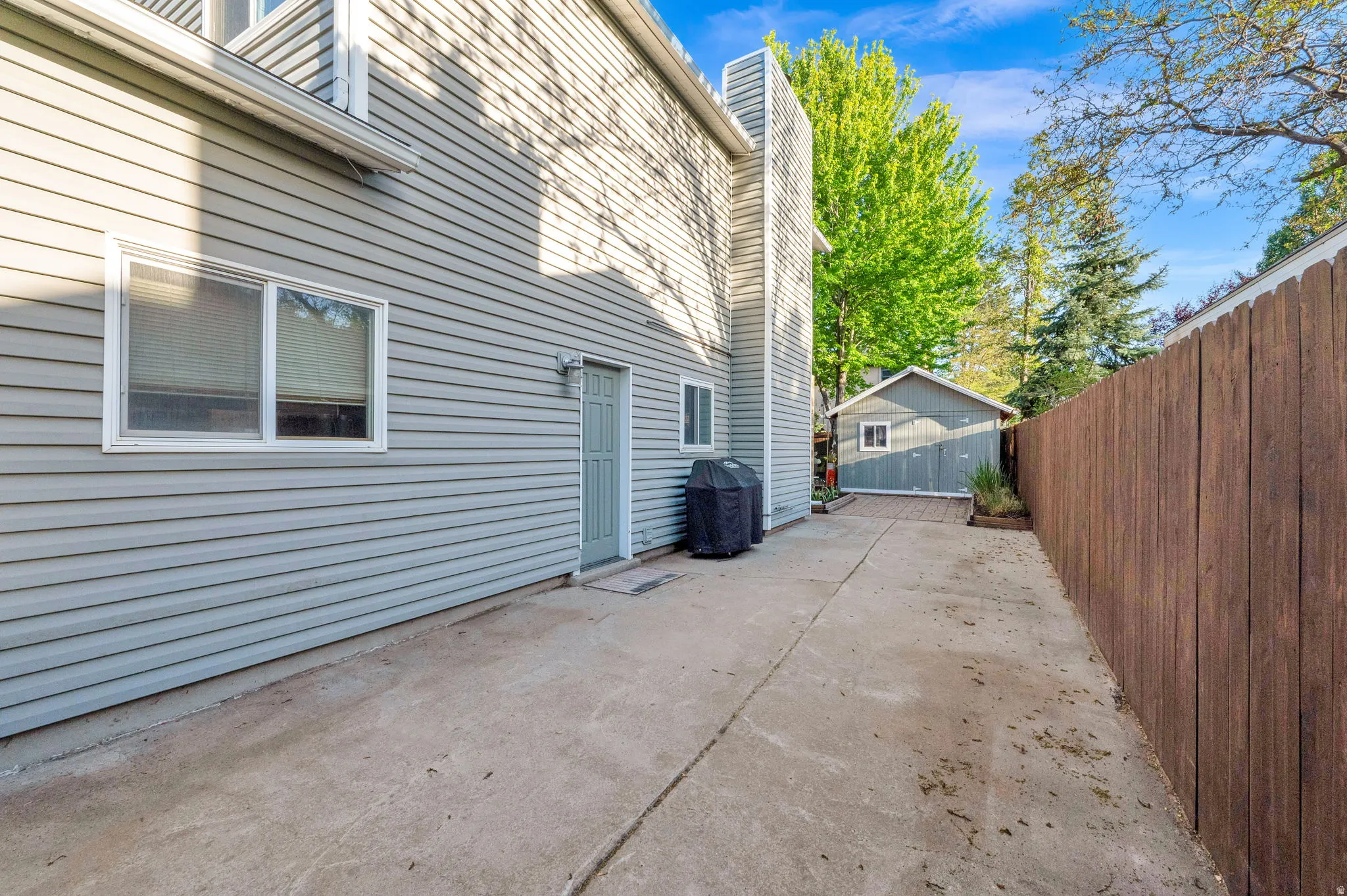 Concrete driveway alongside the property, leading to a detached garage structure