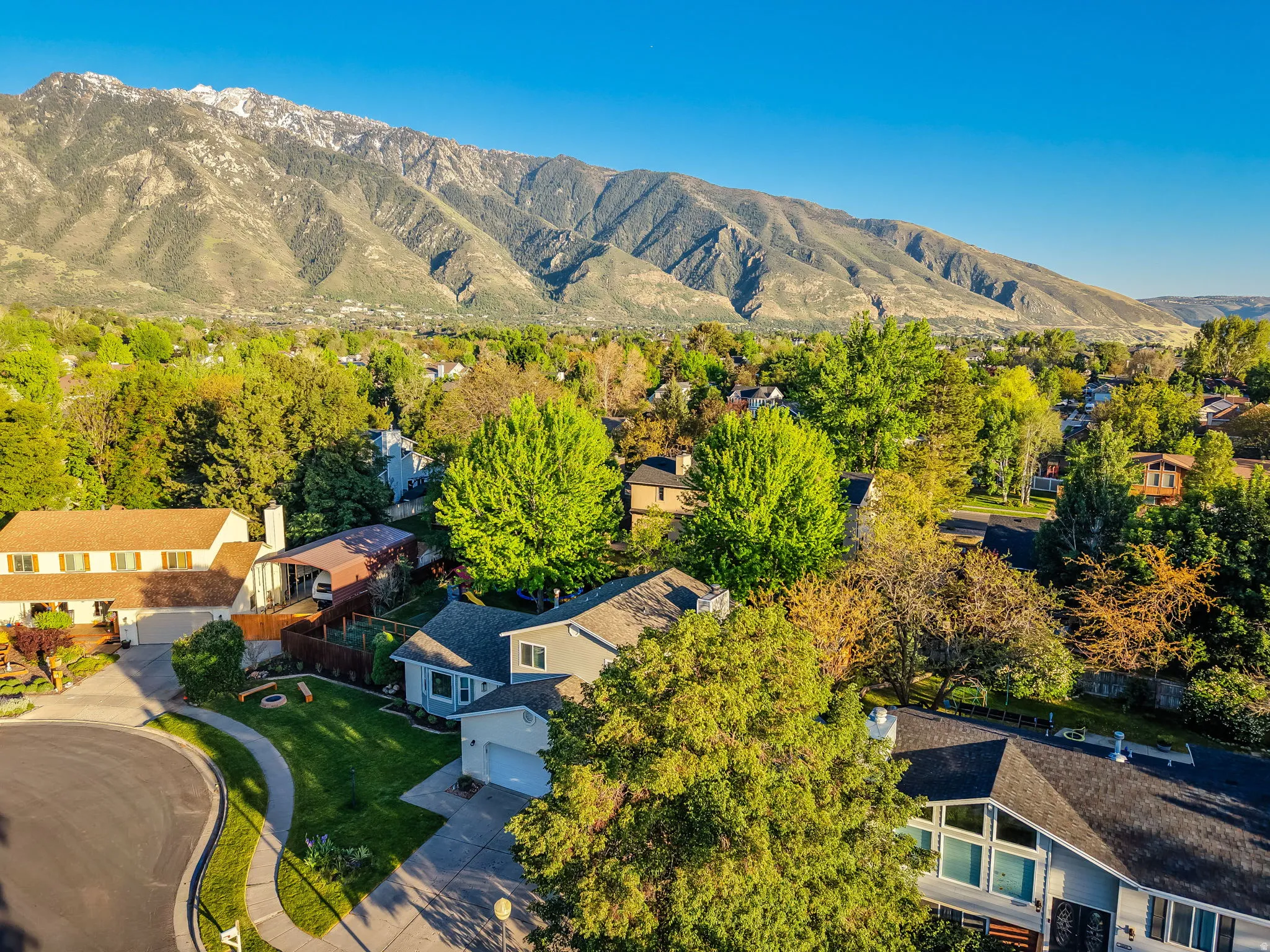Aerial perspective of a neighborhood with a prominent mountain backdrop