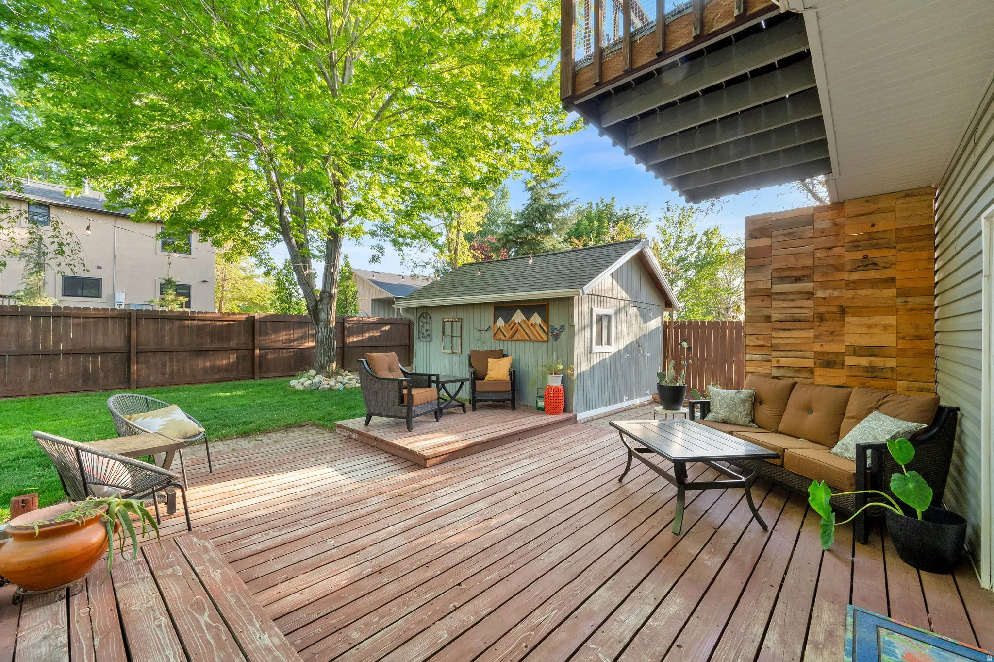 Multi-level wood deck featuring a built-in wood feature wall and fenced yard