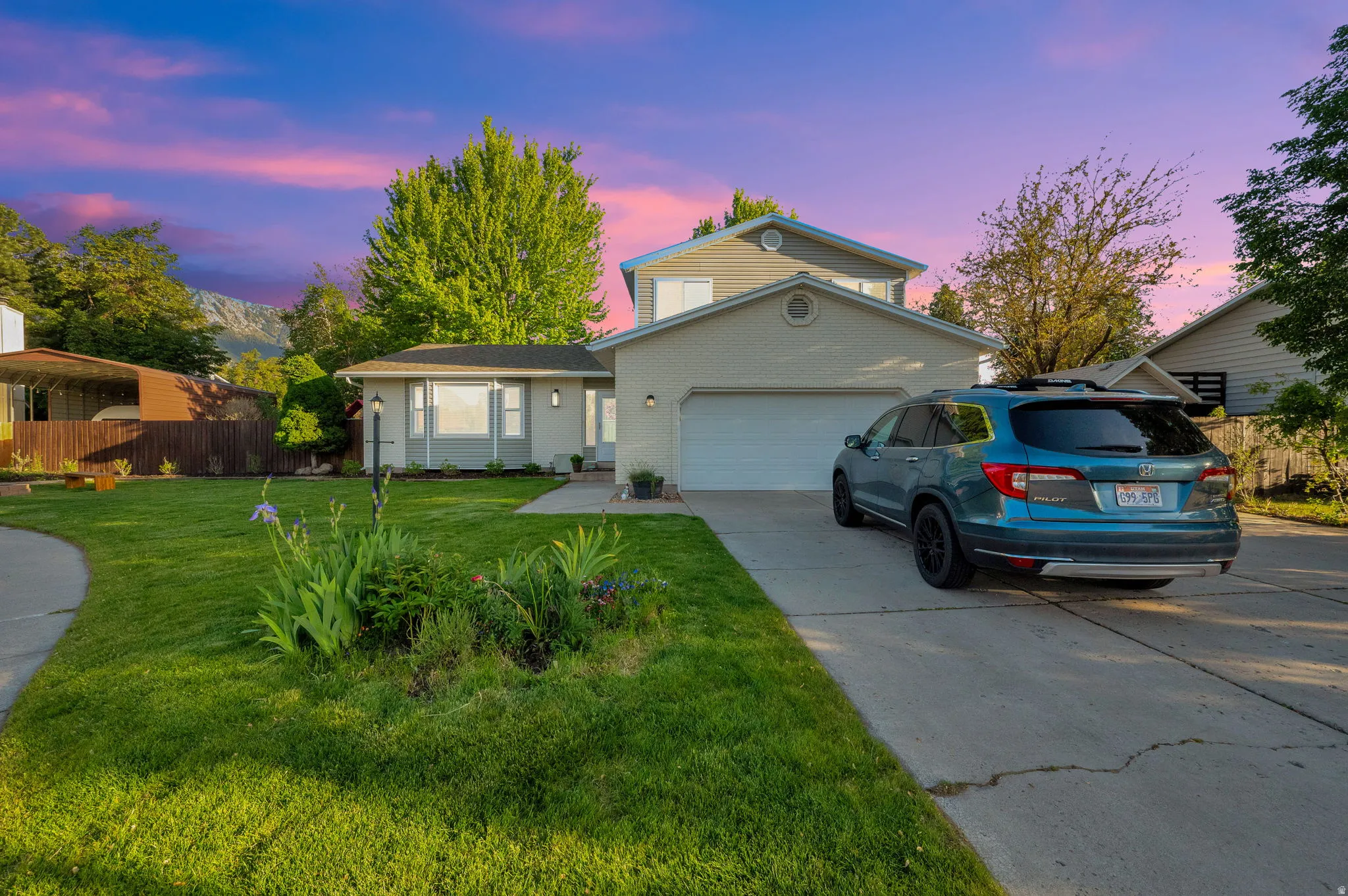 Two-story residence featuring light-colored siding, an attached two-car garage, and a concrete driveway