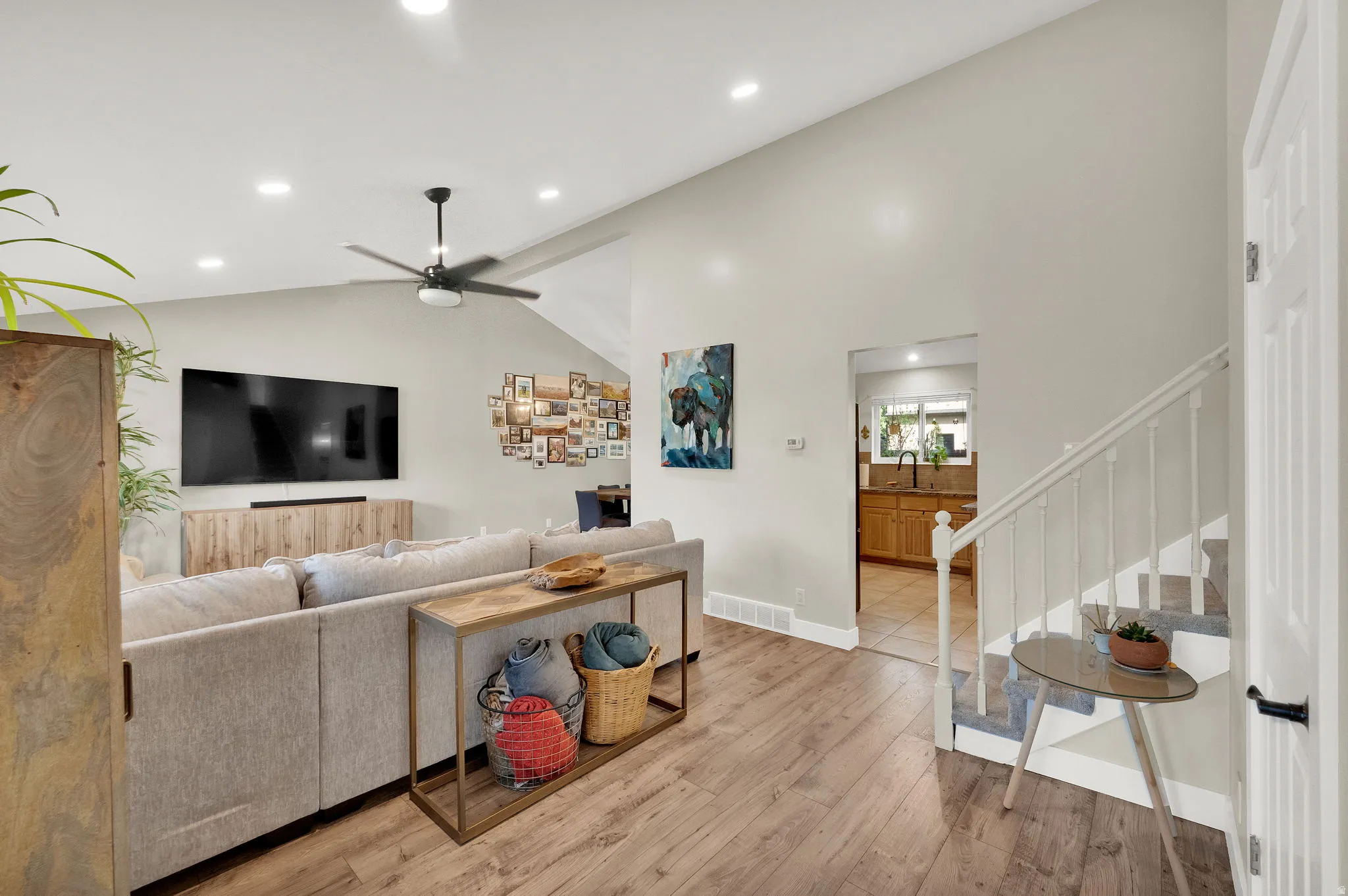Vaulted ceiling great room featuring wood-finish flooring, recessed lighting, and a ceiling fan