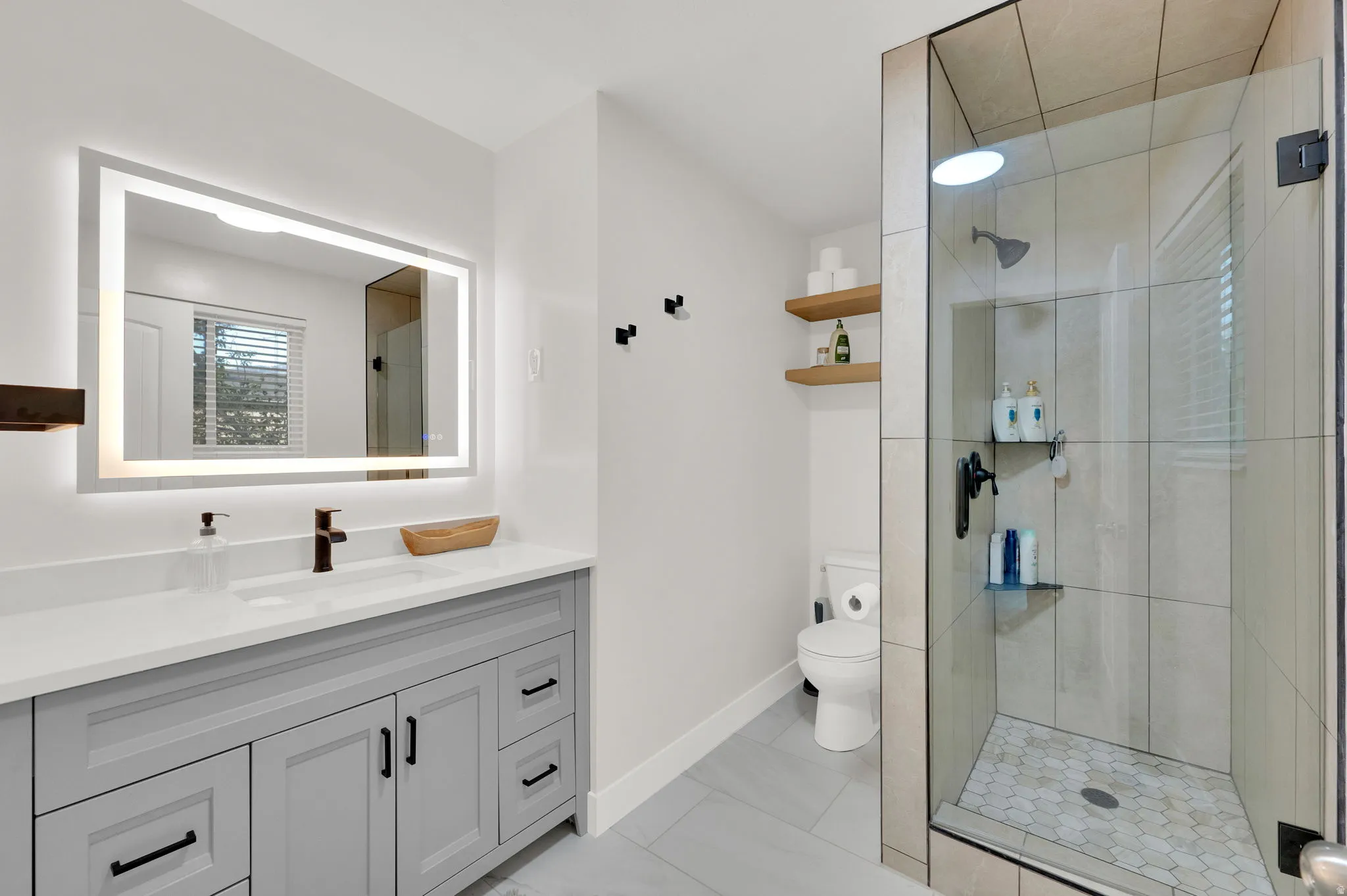 Bathroom featuring a wide vanity with a light gray cabinet base, white countertop, and single basin sink