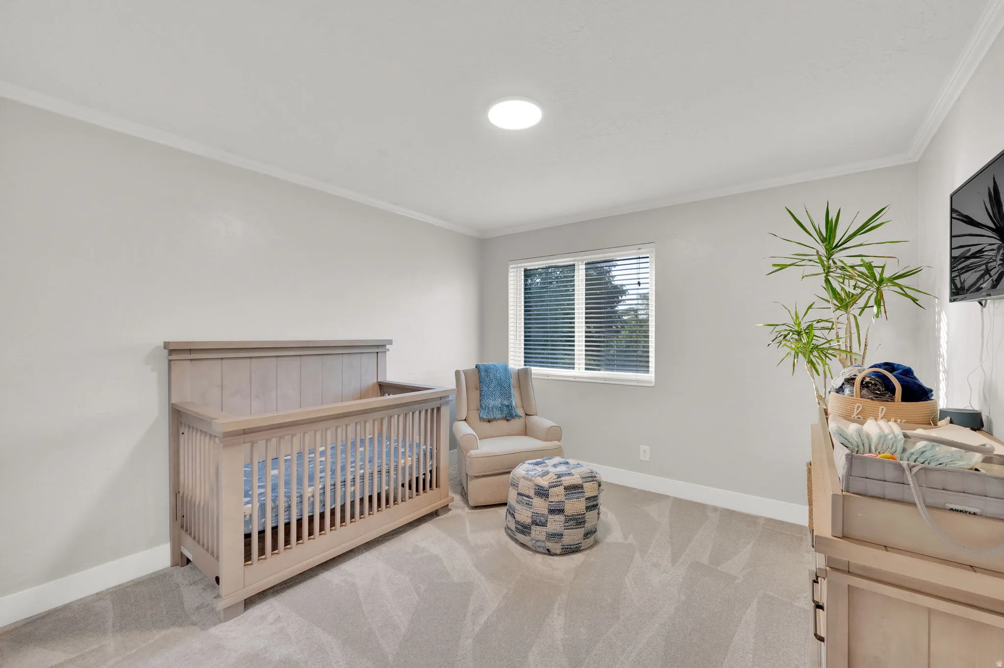 Recessed lighting, crown molding, and light gray wall paint create a bright and neutral interior
