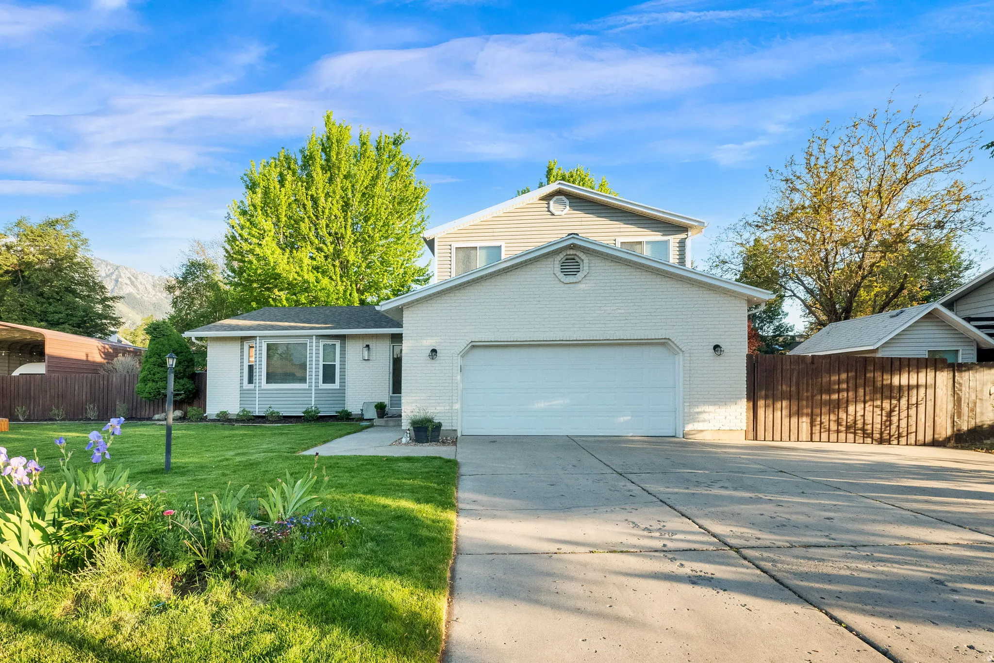 Split-level residence featuring a two-car garage with a concrete driveway