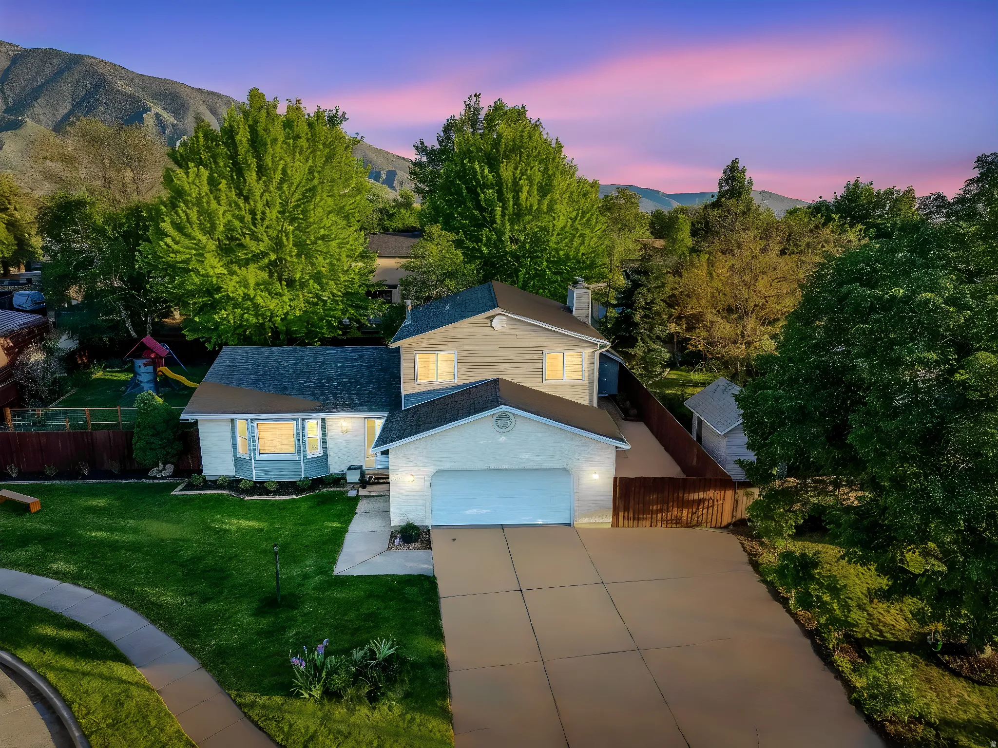 Two-story residence featuring a two-car garage, bay window, and gabled roofline