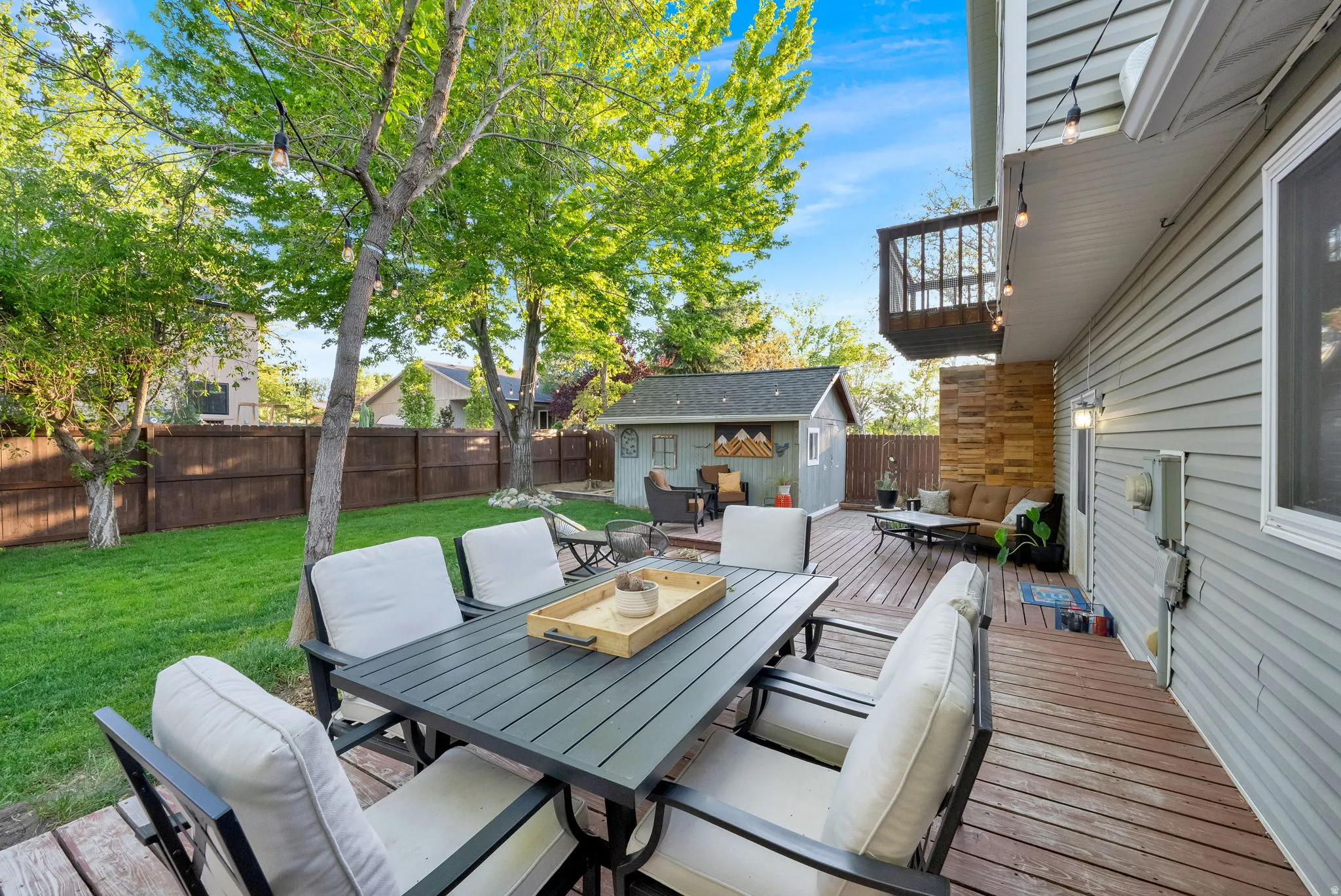 Spacious backyard featuring a multi-level wood deck, manicured lawn, and a privacy fence