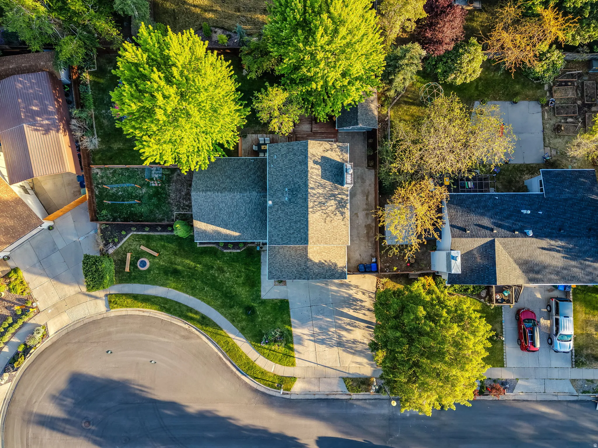 Aerial view showcasing a property with a gray shingle roof and a concrete driveway