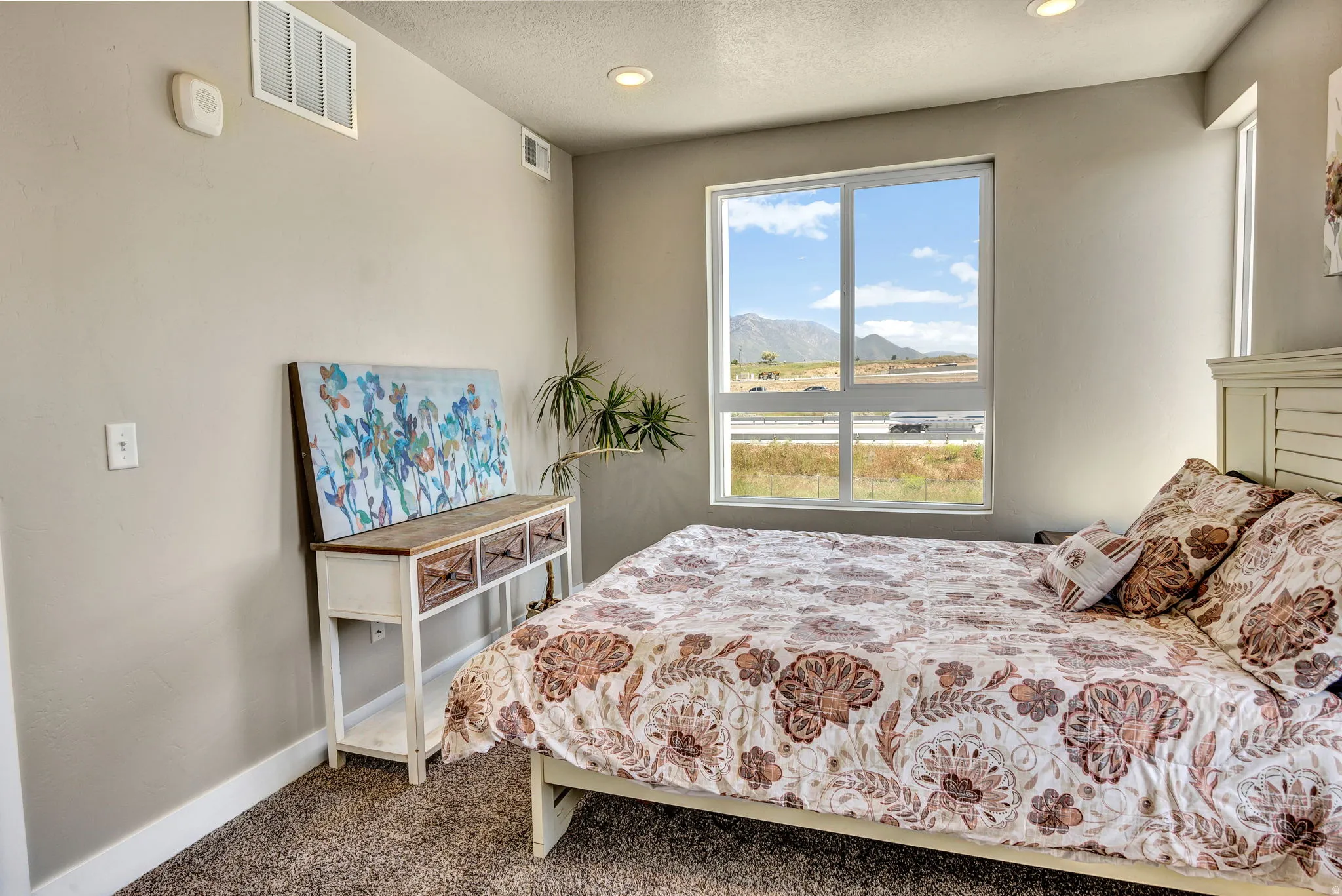 Spacious room featuring a large window, recessed lighting, and neutral-toned walls