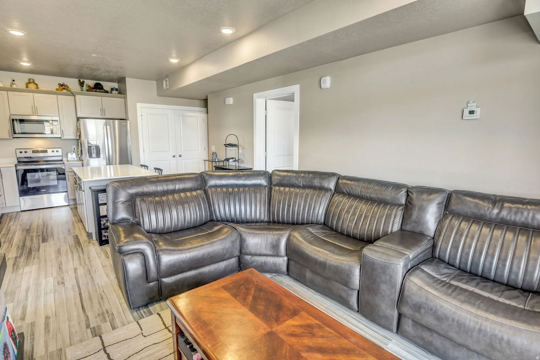 Open-concept living area featuring wood-finish flooring and recessed lighting