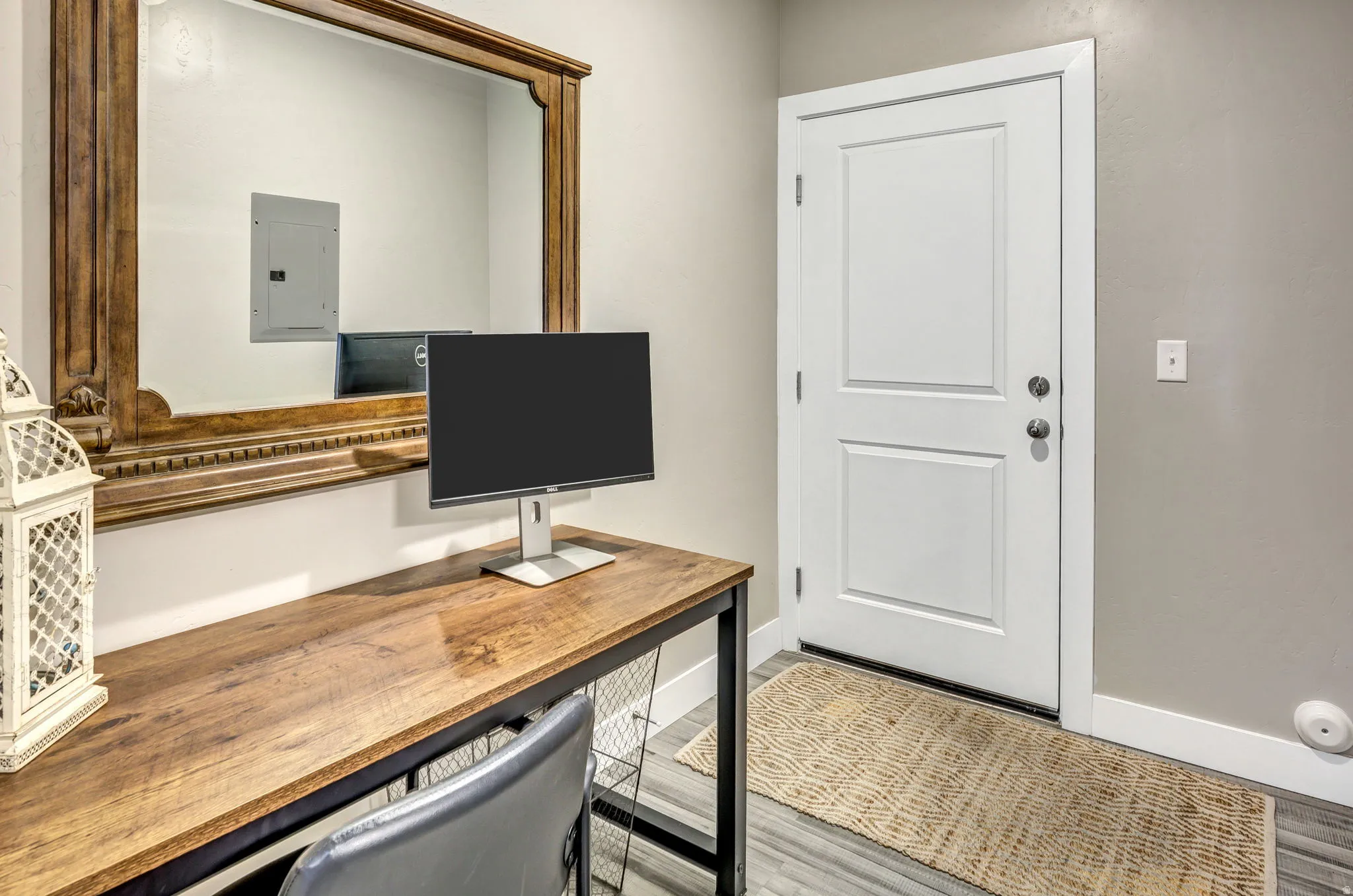 Bright entryway featuring a white panel door and durable wood-finish flooring