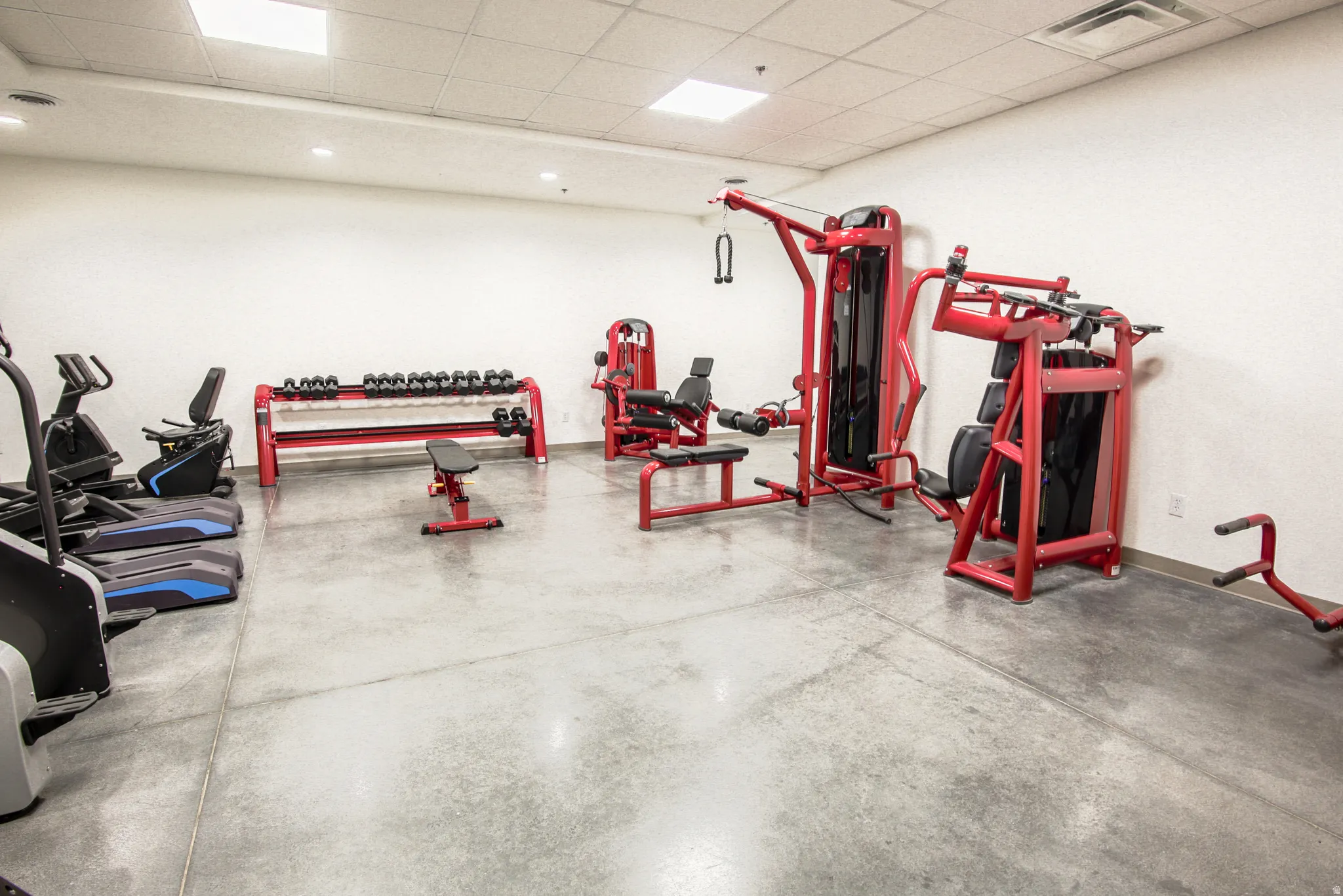 Fitness center featuring concrete flooring and white walls
