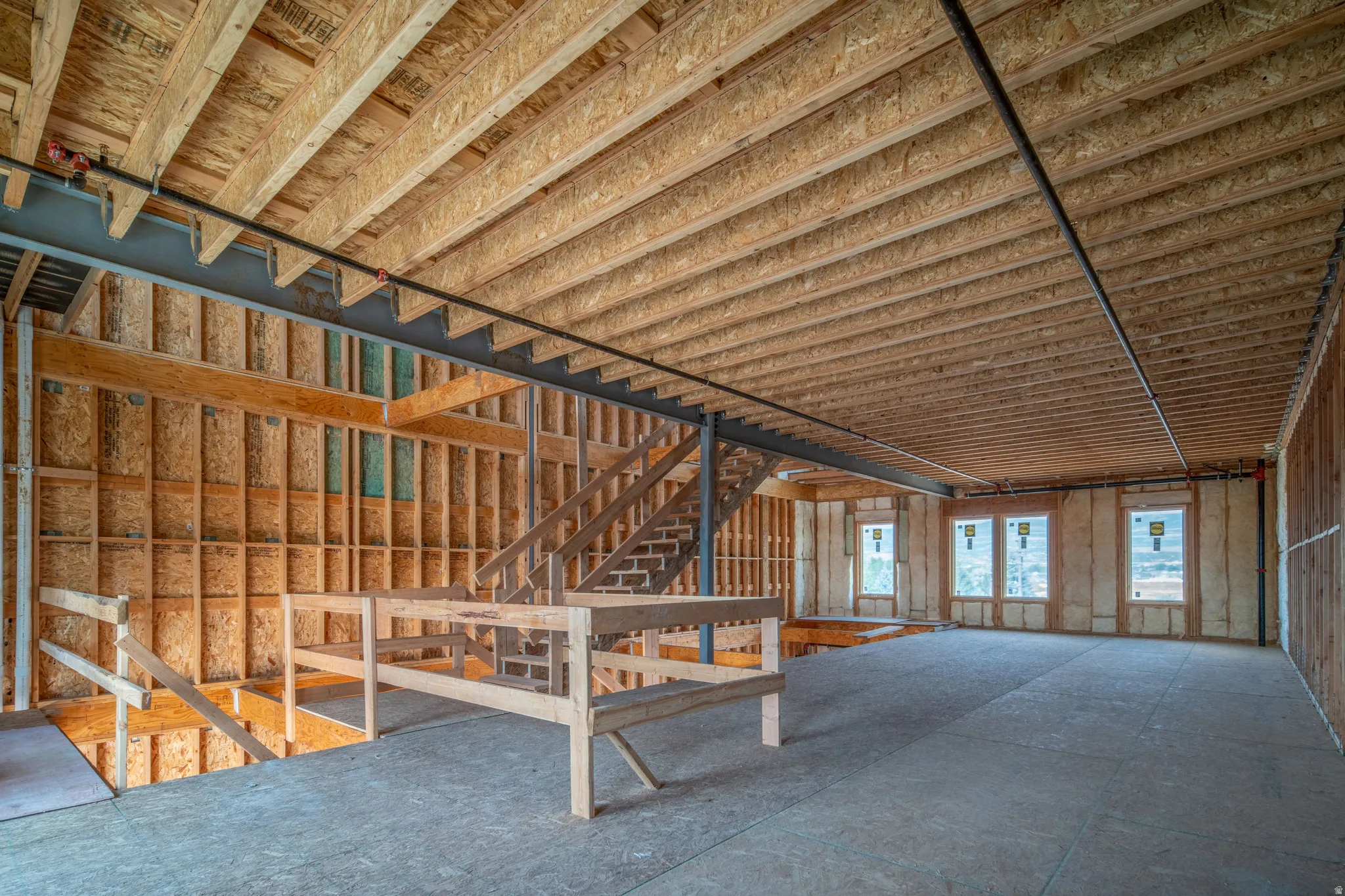 Expansive interior framing featuring exposed wood joists and subflooring