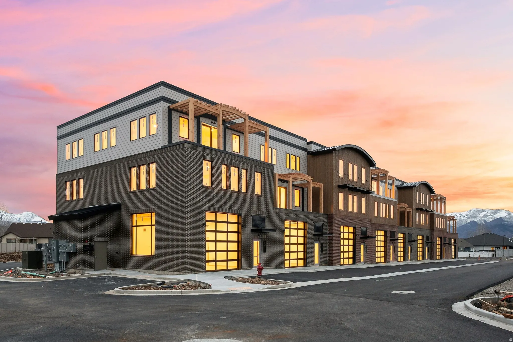 Modern multi-story building featuring dark brick and light-colored siding
