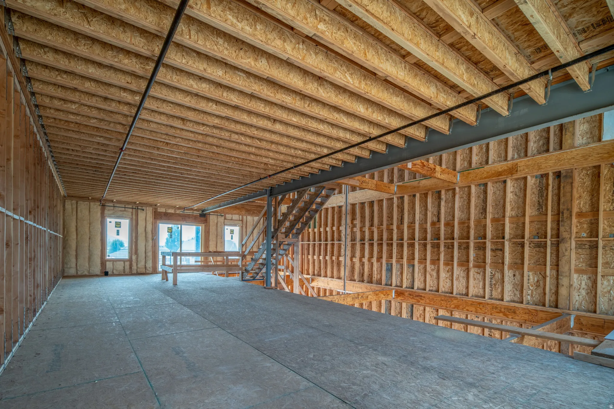 Spacious unfinished interior featuring exposed wood ceiling joists and subflooring