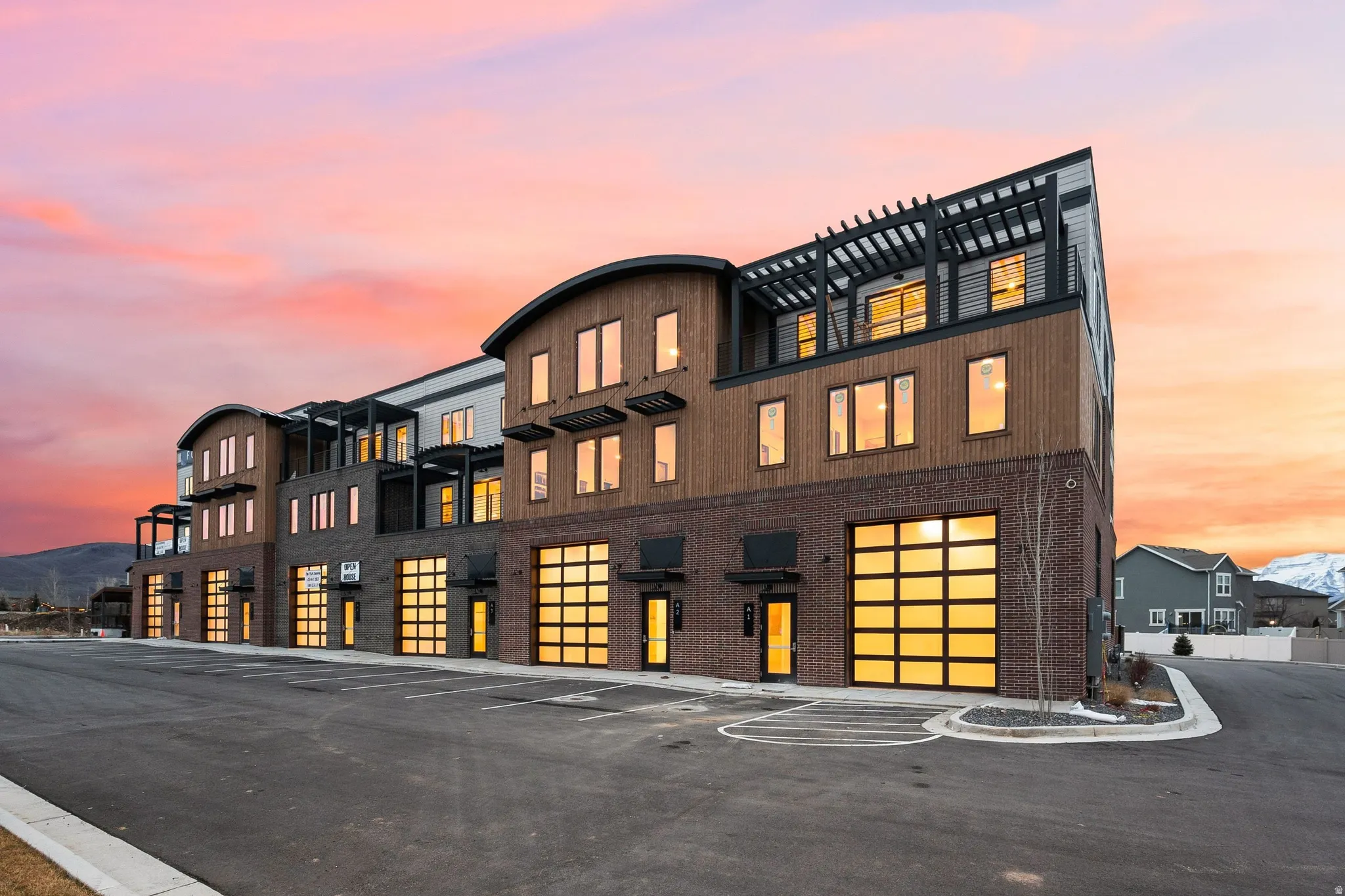 Contemporary multi-story building featuring brick and wood-finish siding with distinctive curved architectural elements