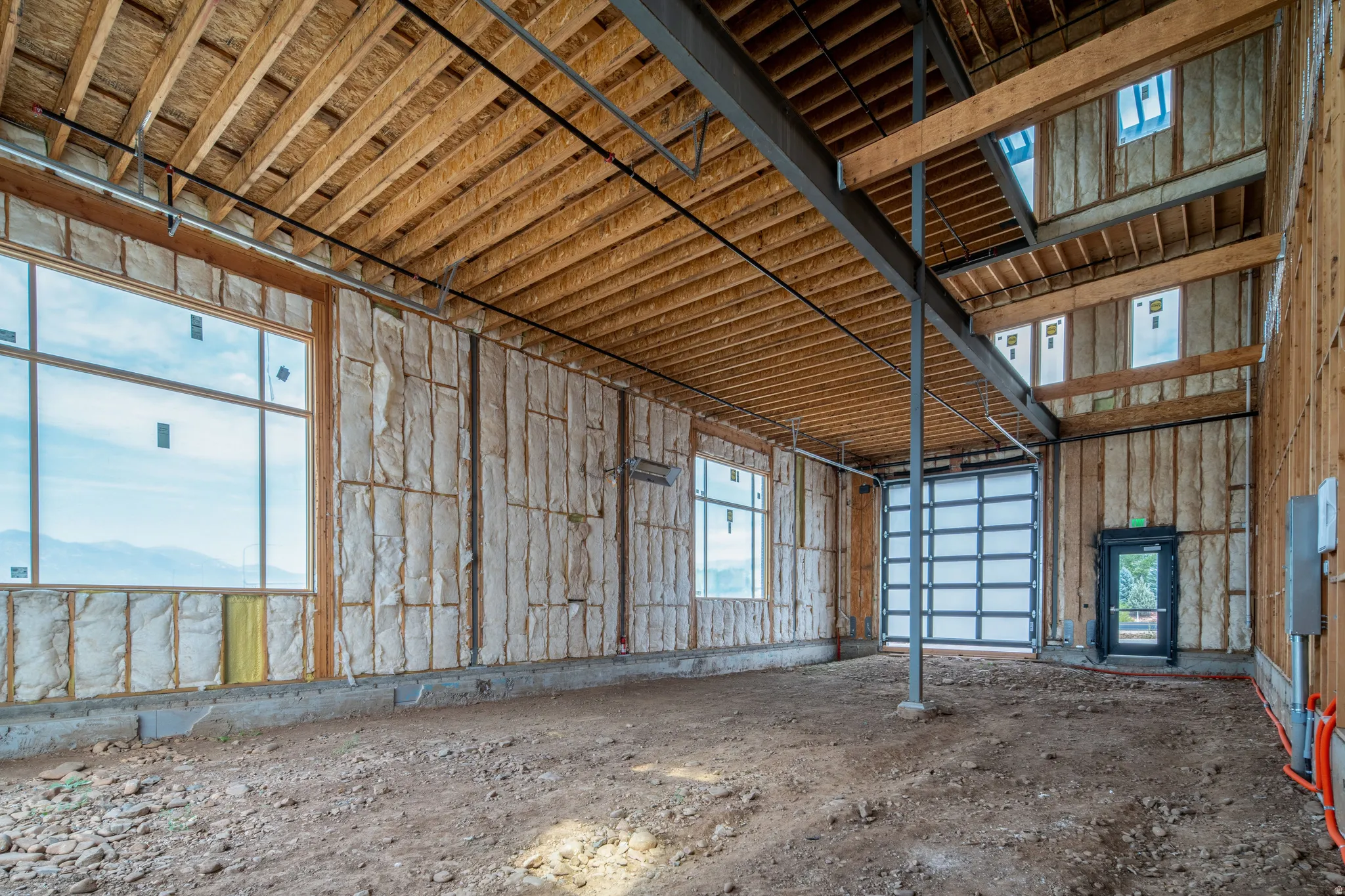 Spacious interior framing, exposed wood ceiling, and multiple large windows