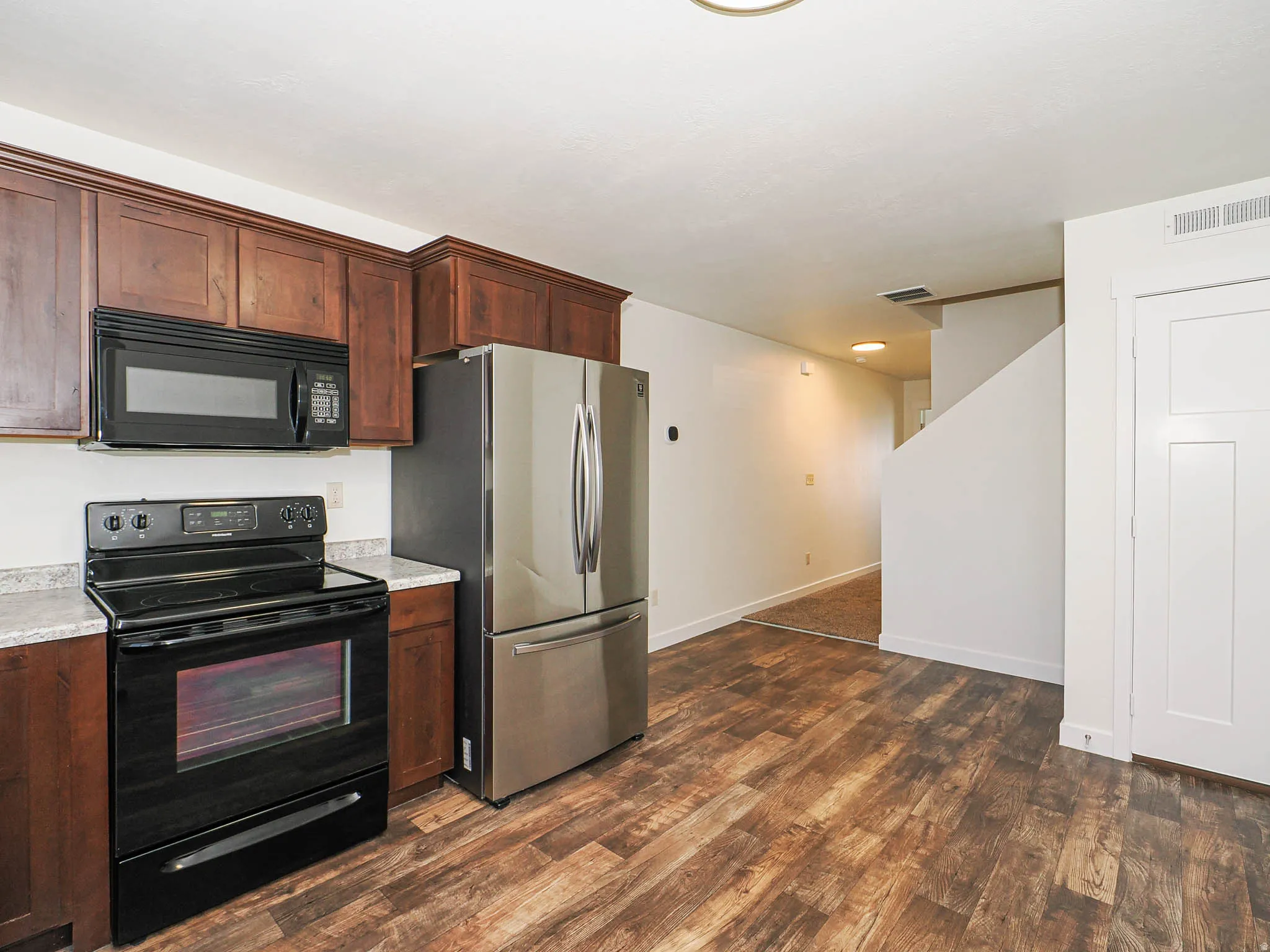 Kitchen area featuring wood-finish flooring and rich wood cabinetry