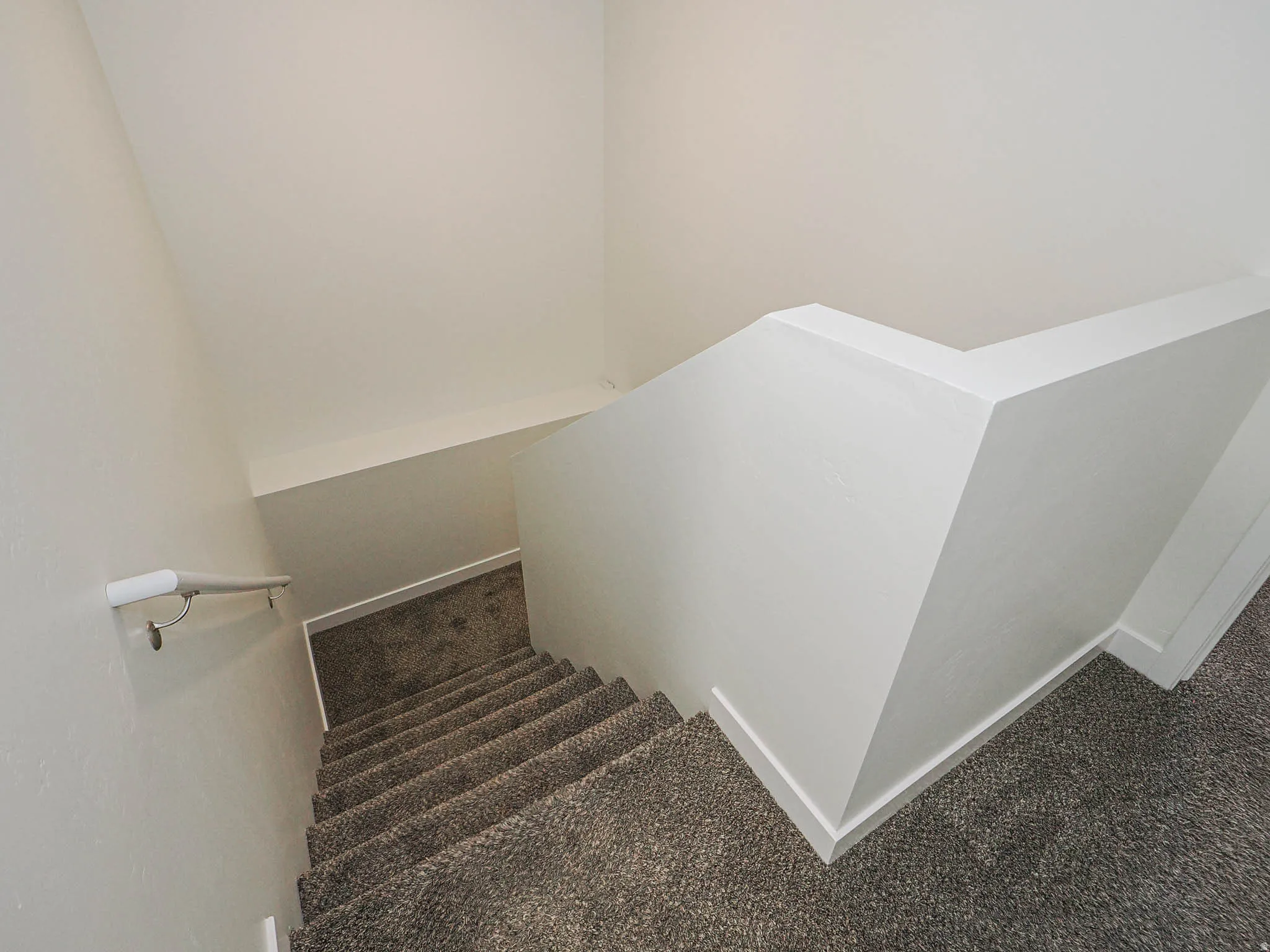 Carpeted staircase with white trim