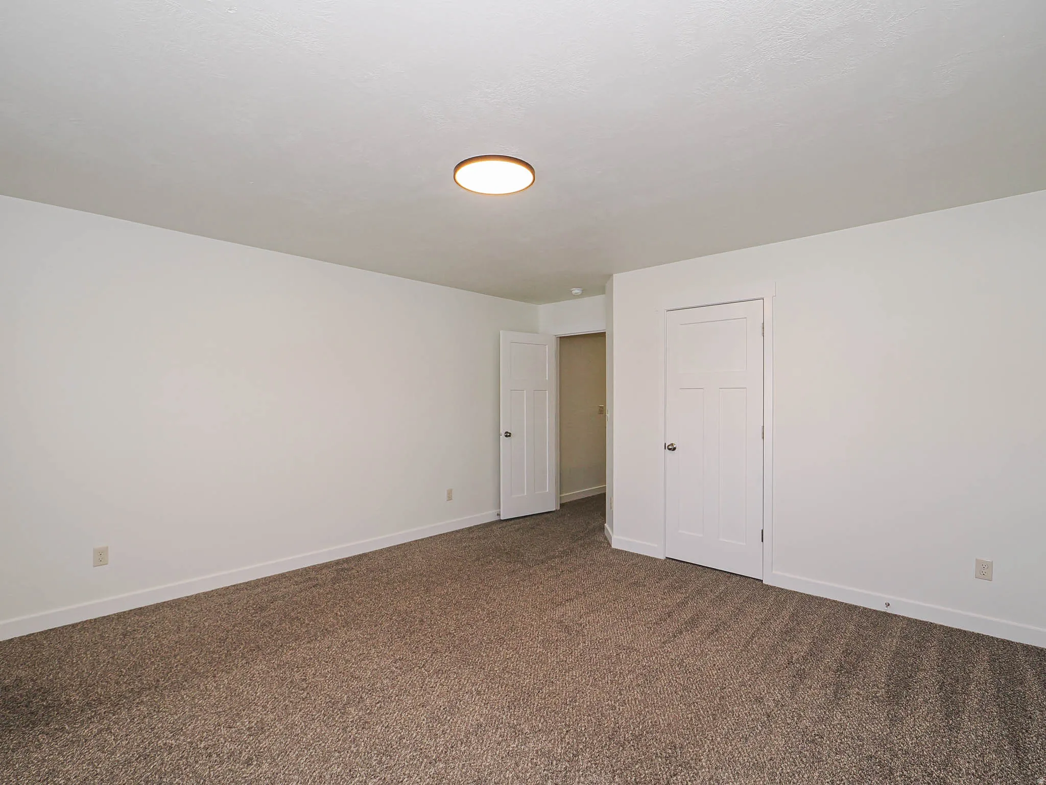 Room featuring neutral-toned carpet flooring and white painted walls