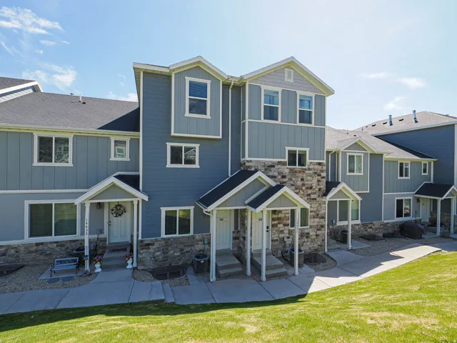Multi-level townhome architecture featuring varied siding textures and stone accents