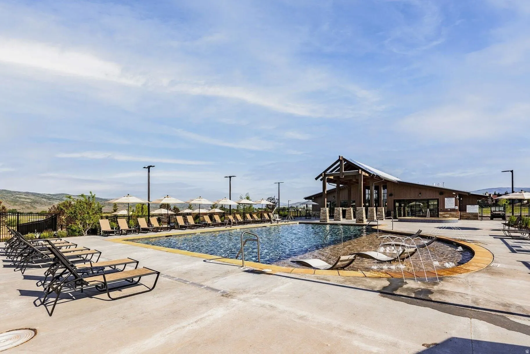 Outdoor swimming pool with integrated lounge seating and water features