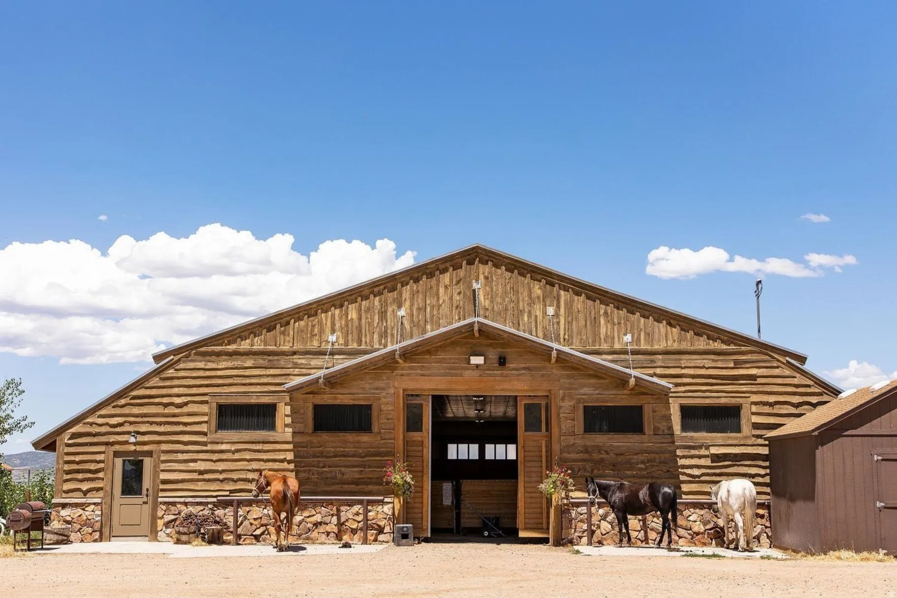 Rustic wood-sided barn with a gabled roofline and stone foundation