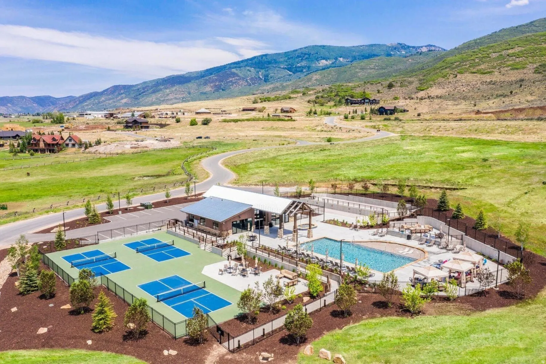 Community recreation area featuring four pickleball courts, a swimming pool, and a structured outdoor lounge space