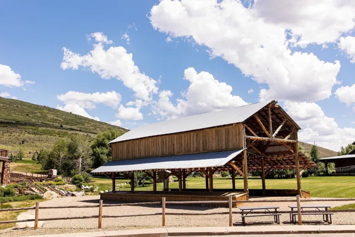 Spacious open-air pavilion featuring exposed timber framing and a metal roof