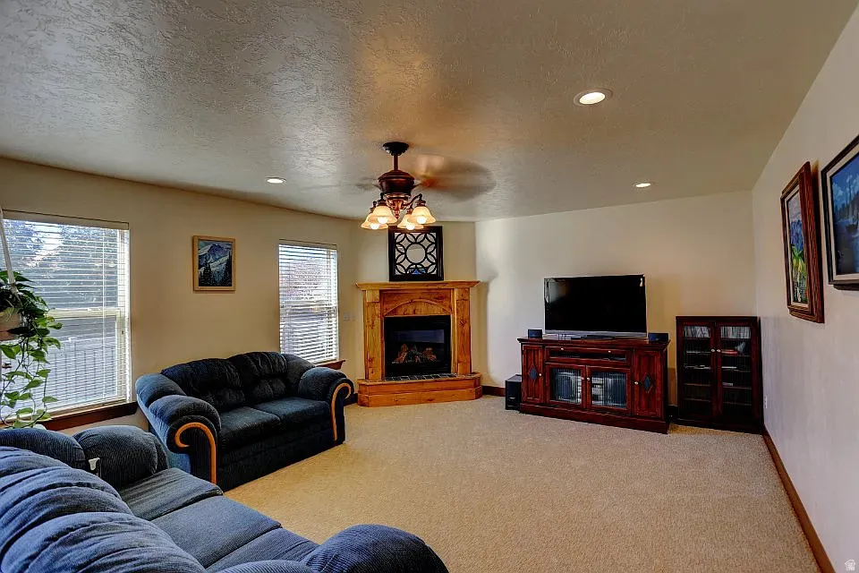 Living area with a corner fireplace featuring a light wood mantel and hearth
