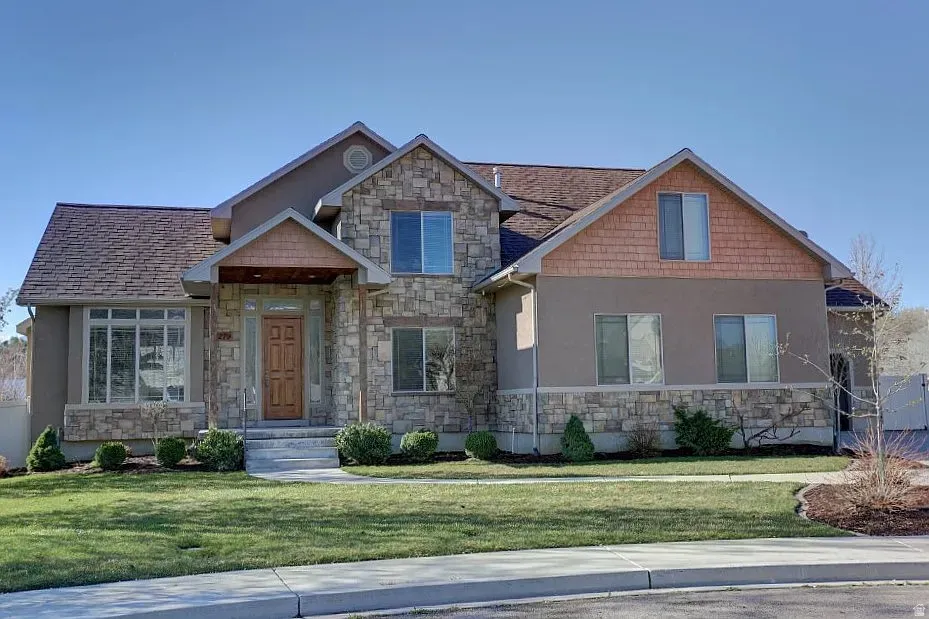 Stone and stucco façade with an inviting covered entry